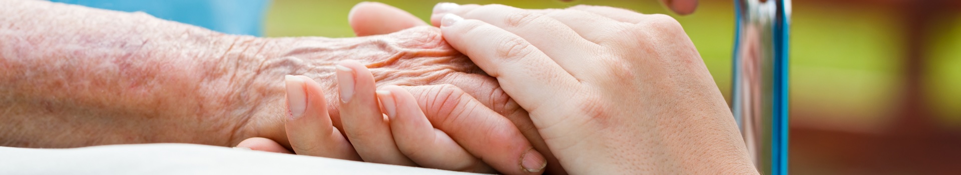 Older person and younger person holding hands